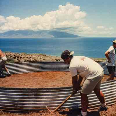 People working on metal water catchment