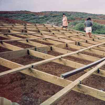 People working on wooden frame of structure base
