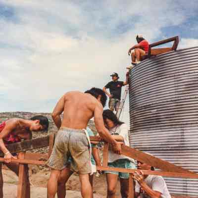 Group of people working on assembling a wooden frame