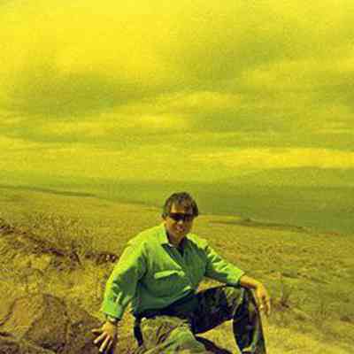Derek Chow sitting on a pohaku (boulder)