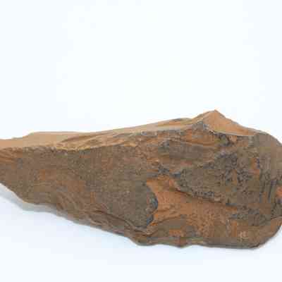 Closeup profile of a possible auger: The image shows a roughly hewn, pointed stone tool, possibly an auger, displaying distinct natural texture and color.