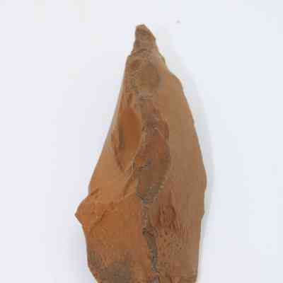 Lengthwise view of a possible auger: The image shows a pointed, brown stone tool resembling an auger, possibly used for drilling.