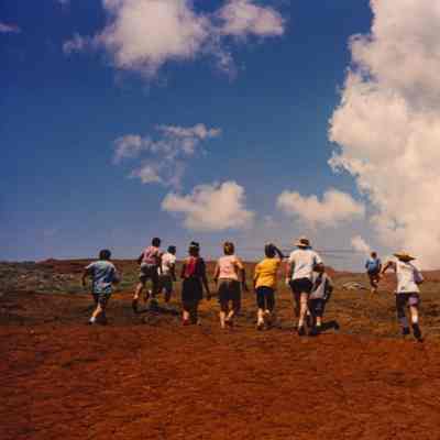 Group of people running toward helicopter landing