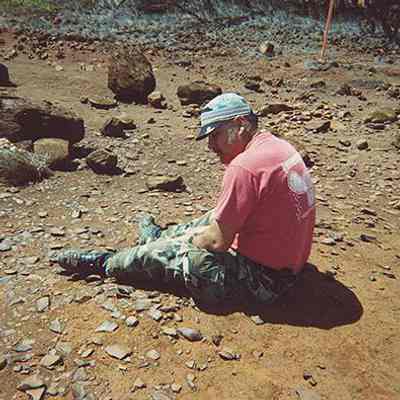Unidentified man sitting in a potential archaeological site