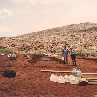Two people standing in front of a wooden frame