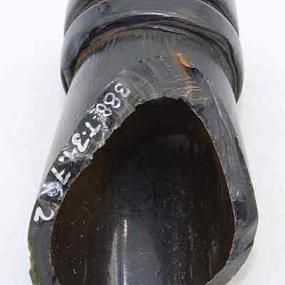Glass bottle fragment with alternate id number visible: The image shows a dark, curved bottle fragment with an irregular edge, displaying numbers inscribed on its surface, for cataloging purposes.
