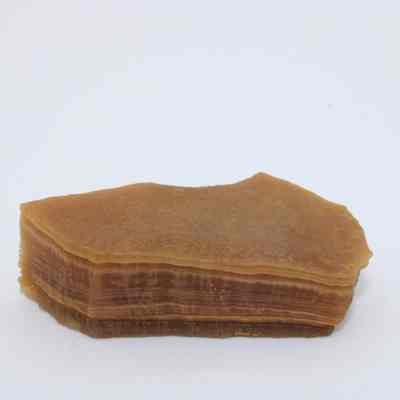 Closeup of agate flake: A brown agate flake with visible layers is displayed against a simple white background, highlighting its natural texture and formation.