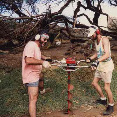 Two men operating an auger