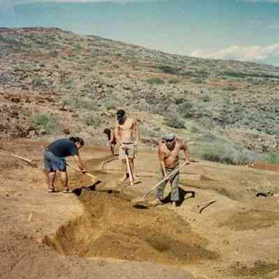 People digging a trench on hardpan