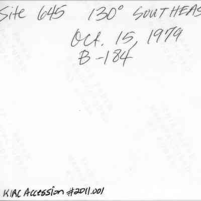 Back of a photo of potential shrine remnants (IMLS Object ID #2011.001.203): The image shows handwritten notes on a paper indicating "Site 645, 130° Southeast, Oct. 15, 1979, B-184."