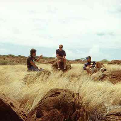 Three unidentified men sitting on pohaku (stones)