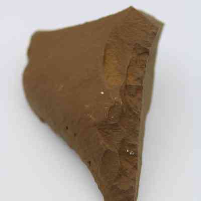 Lengthwise view of basalt awl (kui houhou): The image shows a basalt awl with a rough, brown surface and a pointed end, suggesting its use as a tool.