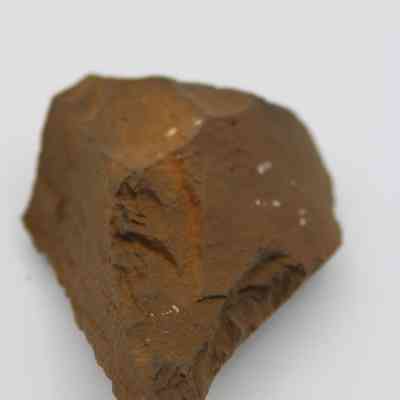 Closeup lengthwise view of basalt awl (kui houhou): The image shows a basalt awl, displaying its rough, pointed end, crafted for piercing, set against a plain white background.