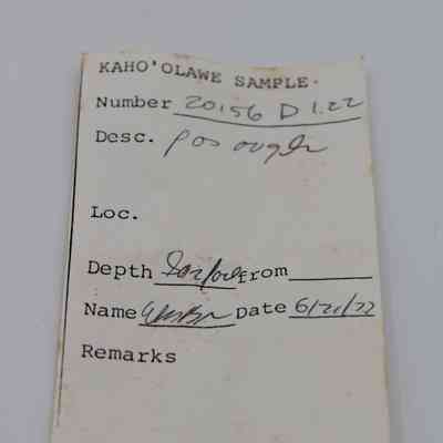 Artifact slip for possible auger: The image shows a handwritten sample tag, labeled "Kaho'olawe Sample," documenting a possible auger description, depth, and date.