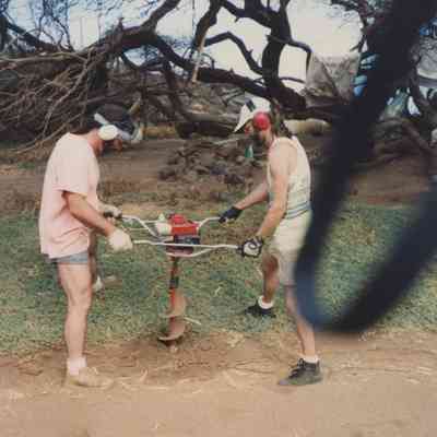 Two men operating an auger