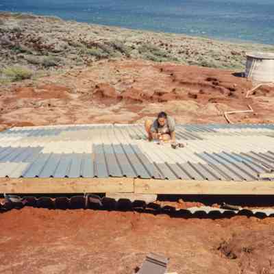 Two people working on water catchment structure