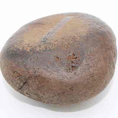 Closeup of a basalt hammerstone: The image shows a rounded, smooth stone with a textured surface featuring various shades of brown and small cracks.