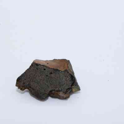 Closeup of glass core: The image shows a small, jagged piece of volcanic glass with a rough, dark surface, likely representing a core sample.