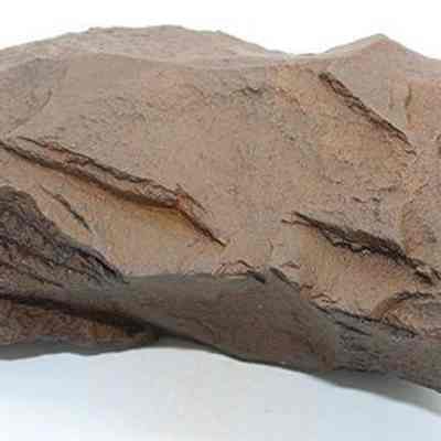 Closeup of basalt adze blank: The image shows a rough, dark brown rock with sharp edges and an uneven surface, probably an adze blank.