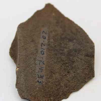 Closeup lengthwise view of basalt flake with visible alternate id number: Origsize: 6.04 cm (l); Origformat: Artifact; Resolution: 200 dpi