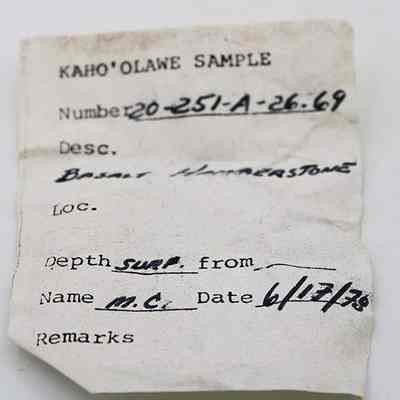 Artifact slip for basalt hammerstone: The image displays a labeled sample tag for an object from Kaho'olawe, featuring details like number, description as basalt hammerstone, depth, and date of collection.