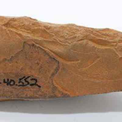 Profile of basalt awl (kui houhou, kui iwi) with alternate id number visible on one side: The image shows an ancient stone awl (kui houhou, kui iwi) with a pointed end, featuring a textured surface and an inscription reading "110AD.40.352" on one side.