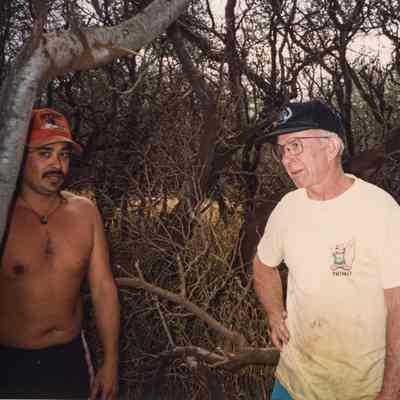 Two men standing in a grove of trees