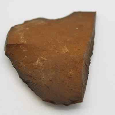 Possible basalt scraper: The image shows a rough, irregularly shaped piece of basalt, possibly a scraper against a white background.