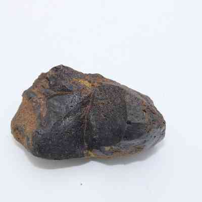 Closeup of pāhoehoe (smooth lava) core: The image shows a dark, rough-textured lava core, displaying earthy tones, against a plain white background.