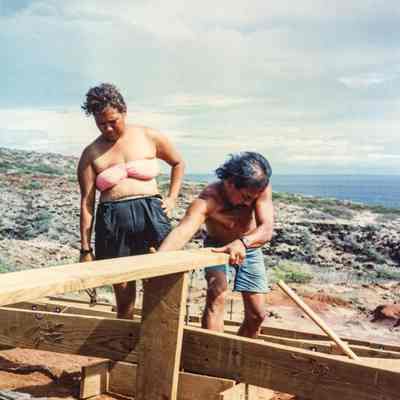 Two people working on a wooden frame