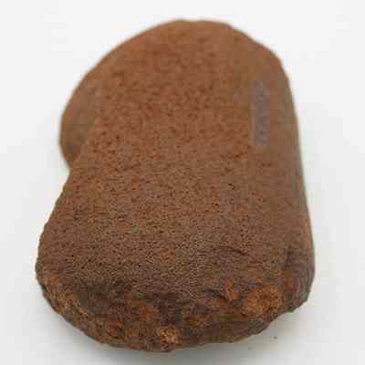 Lengthwise view of a basalt hammerstone: The image shows an ancient hammerstone with a rough texture and worn edges, commonly used for shaping and processing other materials.