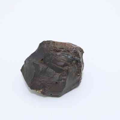 Closeup of basaltic glass core: The image shows a piece of basaltic glass core with a rough, irregular shape and dark surface texture.