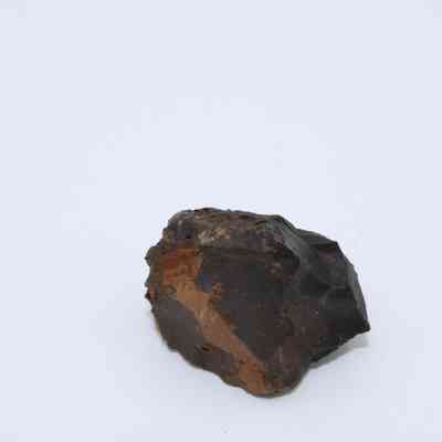 Basaltic glass core: The image shows a small, rough, dark-colored basaltic glass core, displaying uneven surfaces and earthy tones.
