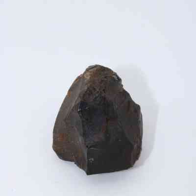 Closeup of basaltic glass core: The image depicts a jagged basaltic glass core with rough surfaces, showcasing its dark, lustrous texture against a plain white background.