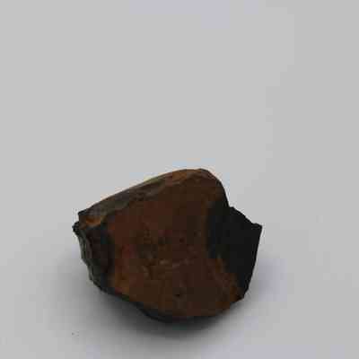 Basaltic glass core: The image shows a small, irregularly shaped piece of basaltic glass core with a dark, glossy surface on one side.