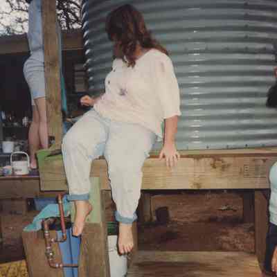 Person sitting next to water storage tank