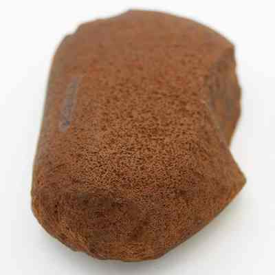 Closeup lengthwise view of a basalt hammerstone: The image shows a weathered hammerstone with a rough, textured surface, typically used as a tool for shaping or striking objects.