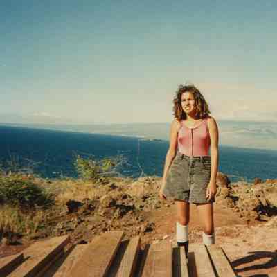 Unidentified woman standing next to lumber
