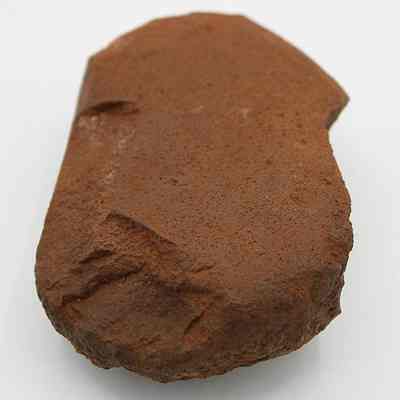 Lengthwise view of a hammerstone: The image shows a brownish, roughly textured hammerstone with worn edges, traditionally used in early toolmaking.