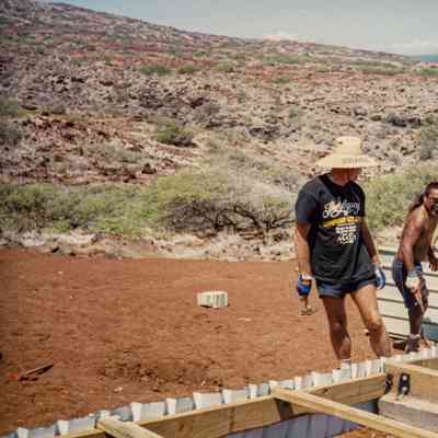 People working on the side of a water catchment structure