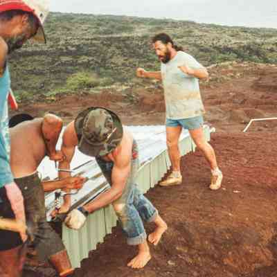 People drilling nail into water catchment structure