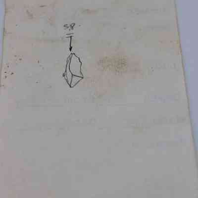 Back of artifact slip: The image shows an artifact slip with a rough sketch of an object labeled "S.P," featuring faint background text obscured by dirt.