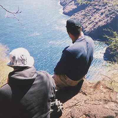 Two people sitting on cliff