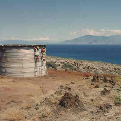 Two people working on water tank