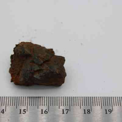 Basaltic glass core with ruler: The image shows a small basaltic glass core placed beside a ruler for scale measurement and observation.