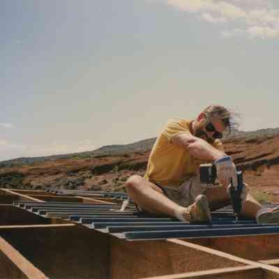 Man inserting screw into water catchment