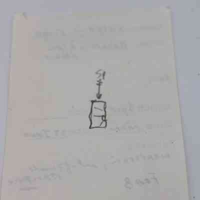Back of artifact slip for basaltic glass flake: The image depicts an artifact slip with a handwritten diagram, arrow, and some faint, illegible text in the background, on white paper.