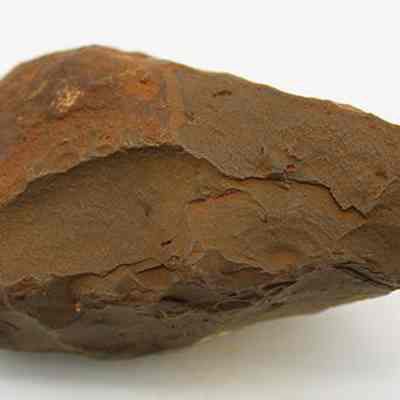 Profile of basalt hammerstone: The image shows a rough, stone hammerstone or adze preform with an elongated, pointed shape and textured surface, likely used in early tool-making.