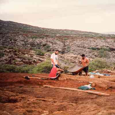 People pouring concrete at wooden frame