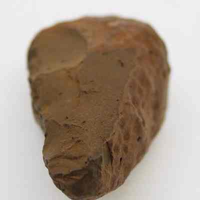 Lengthwise closeup view of basalt hammerstone: The image shows a stone tool that could either be a hammerstone or an adze preform, characterized by its rough, irregular surface and uneven edges.
